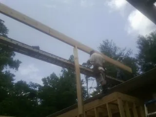 Carpenter setting a ridge beam over a new addition frame — Ice Dam Removal by Roofing Brothers in Ridgewood