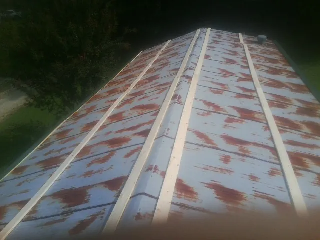 Rusted metal roof panels with new wood purlins before replacement — Storm Damage Roof Repair in Ridgewood by Roofing Brothers